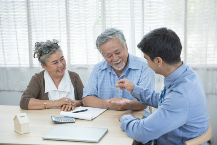 happy older couple with insurance agent